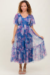 woman wearing a blue floral midi dress with puff sleeves and a tiered tulle skirt