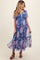 woman wearing a blue floral maternity dress with short flutter sleeves and a tiered skirt, showcasing her baby bump