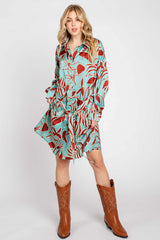 woman wearing a teal floral shirt dress with long sleeves and brown cowboy boots