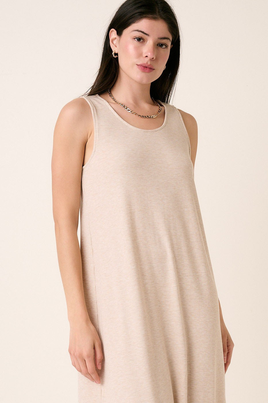 woman wearing a beige sleeveless ribbed midi dress with a relaxed fit