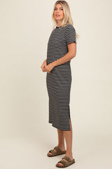 woman wearing a black and white striped midi dress with short sleeves and side slits, styled with brown sandals