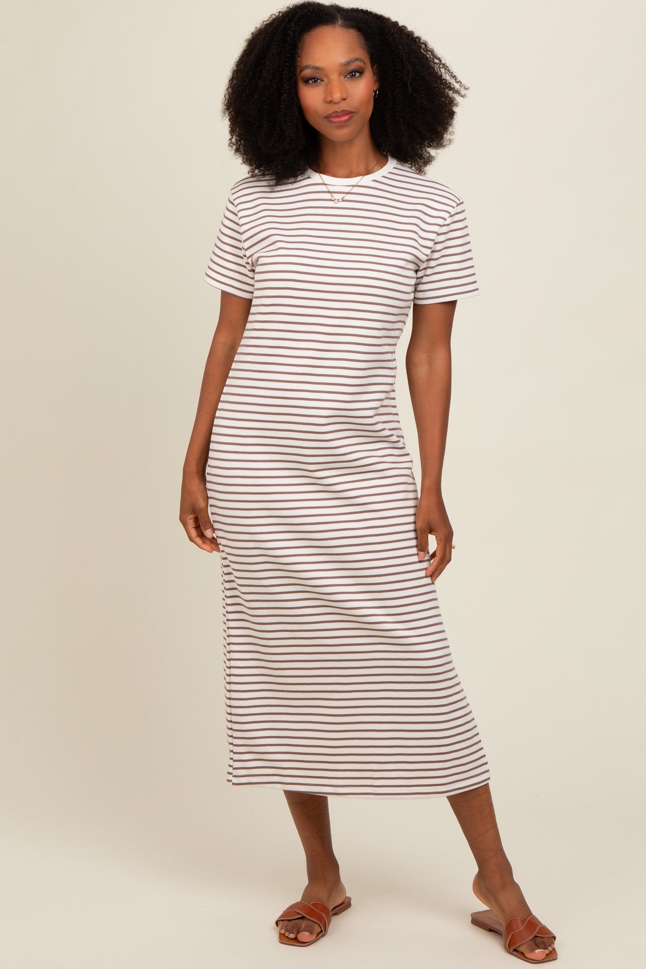 woman wearing a short sleeve striped midi dress in cream and brown with side slit and brown sandals
