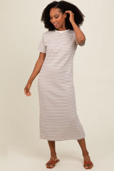 woman wearing a beige and white striped midi dress with short sleeves and a relaxed fit, standing and smiling