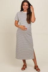 woman wearing a striped maternity maxi dress with short sleeves and a side slit, gently holding her baby bump