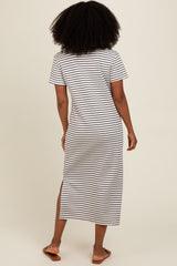 woman wearing a black and white striped maxi dress with short sleeves and side slits, viewed from the back