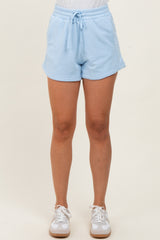 woman wearing light blue short athletic shorts with a drawstring waist and side pockets