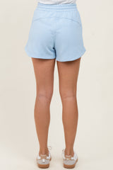 woman wearing light blue shorts with a relaxed fit and elastic waistband, viewed from the back