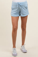 woman wearing light blue maternity shorts with a drawstring waist and white sneakers
