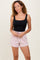 woman wearing a black fitted tank top and light pink drawstring shorts