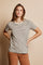 woman wearing a striped short sleeve top in beige and brown with hands on hips