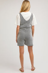 woman wearing a striped black and white maternity romper with shorts, viewed from the back