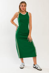 woman wearing a green sleeveless midi dress with white side stripes and white trim