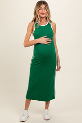 woman wearing a green maternity sleeveless dress with white stripes, holding her baby bump