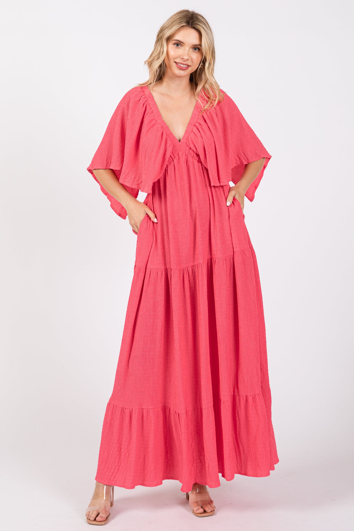 woman wearing a pink tiered maxi dress with short flutter sleeves and pockets