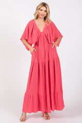 woman wearing a pink tiered maxi dress with short flutter sleeves and pockets