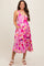 woman wearing a pink patterned maternity dress with pockets, showcasing her baby bump