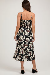 woman wearing a black and white floral print maternity dress with spaghetti straps and a fitted bodice