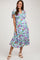 woman wearing a light blue floral maternity dress with short flutter sleeves and a flowy skirt, showing her baby bump