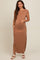 woman wearing a brown sleeveless maternity maxi dress and showing her baby bump