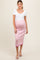 woman wearing a fitted white maternity top and a pink ribbed maternity skirt, showcasing a baby bump
