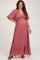 woman wearing a pink floral maternity maxi dress with a deep V-neck and ruffled hemline, showing her baby bump
