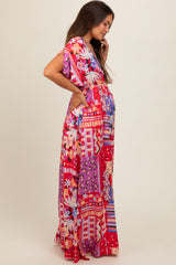 woman wearing a vibrant floral print maternity maxi dress with short sleeves and a baby bump visible