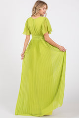 woman wearing a bright lime green pleated maxi dress with short flutter sleeves and a cinched waist