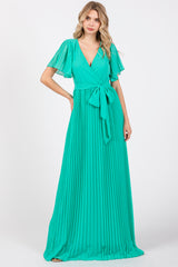 woman wearing a mint green pleated maxi dress with a wrap style and flutter sleeves, tied at the waist