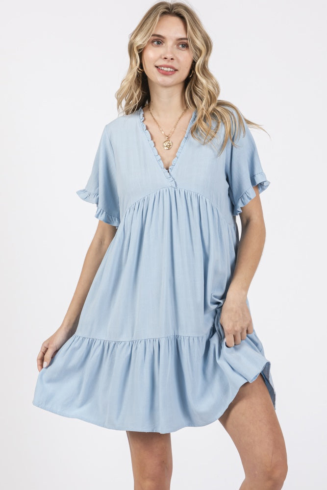 woman wearing a light blue short sleeve tiered dress with a v-neck and ruffle details