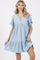 woman wearing a light blue short sleeve tiered dress with a v-neck and ruffle details