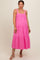 woman wearing a pink maternity dress with tiered design and adjustable straps, showcasing a baby bump