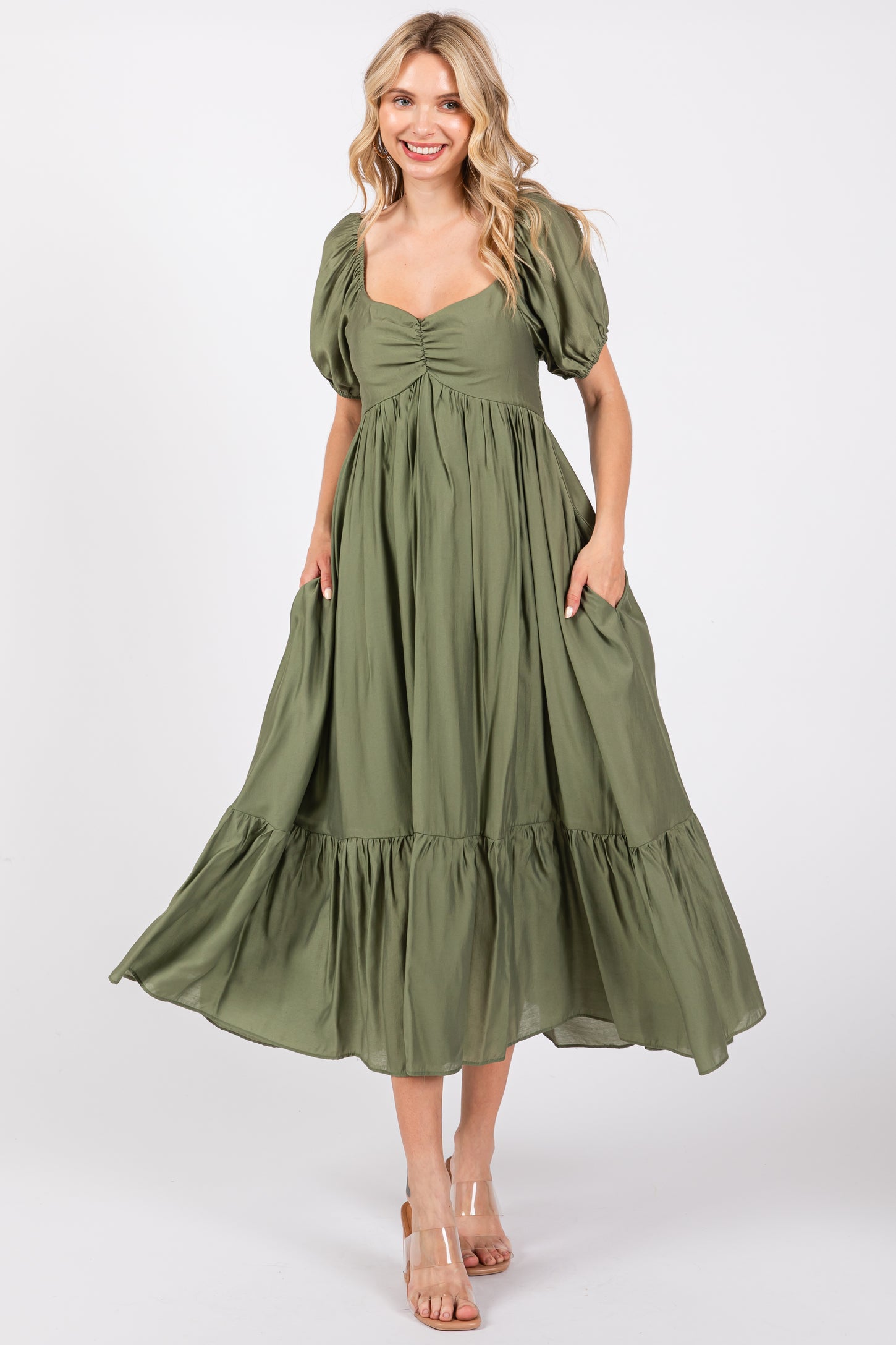 woman wearing a green puff sleeve maxi dress with a tie front and side pockets