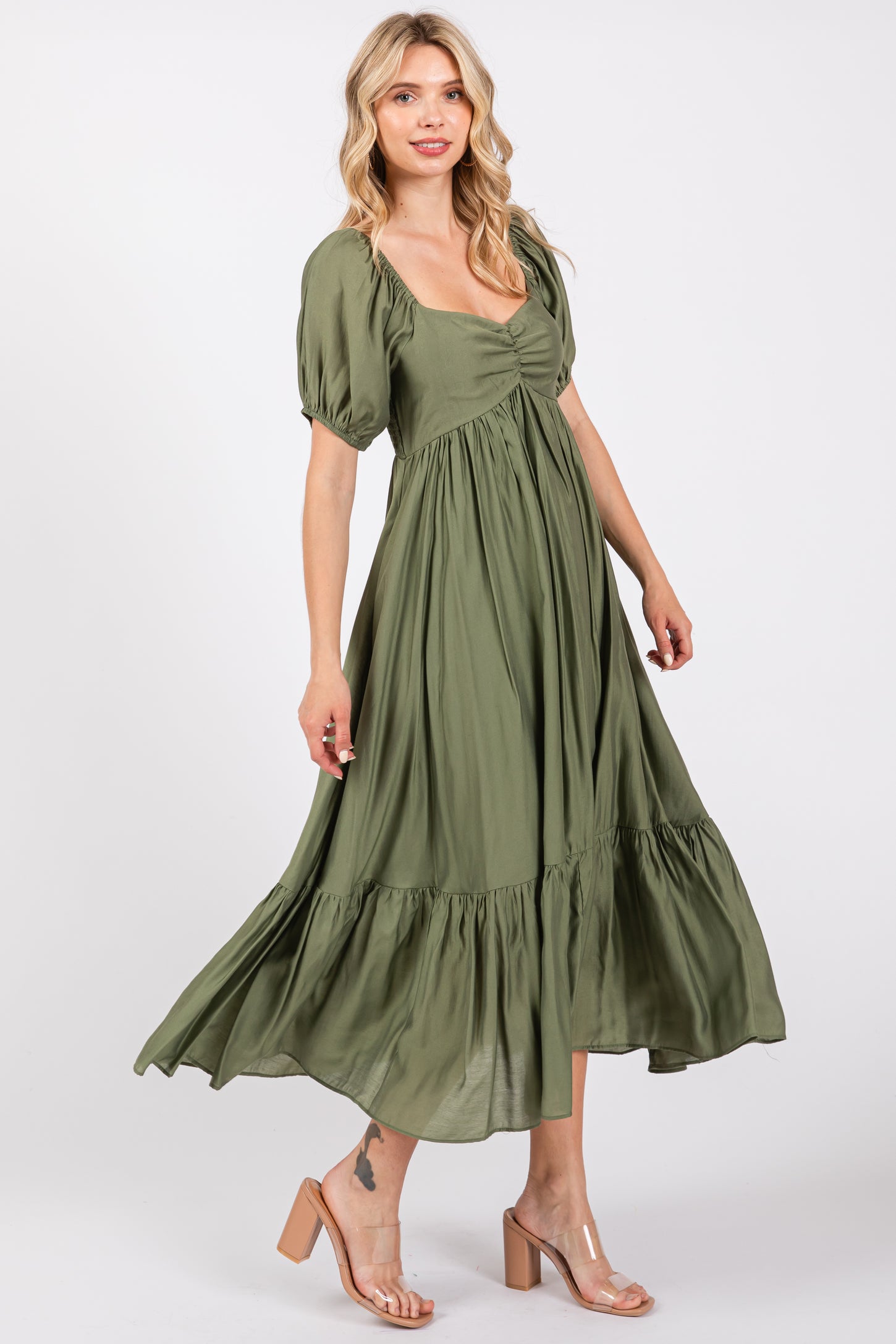 woman wearing a green puff sleeve maxi dress with a square neckline and ruffle hem, standing in a flowy pose