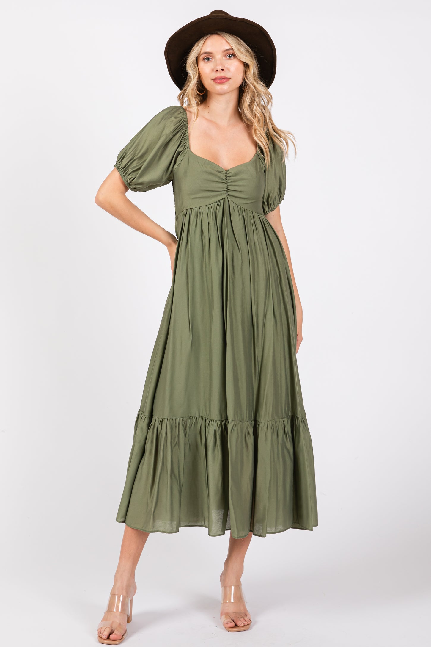 woman wearing an olive green puff sleeve midi dress with a tiered skirt and a square neckline, paired with a wide-brim hat