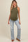 woman wearing an olive green ribbed maternity tank top and light blue distressed wide-leg jeans, showing her baby bump