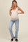 woman wearing a nude maternity tank top and light blue jeans, showing her baby bump