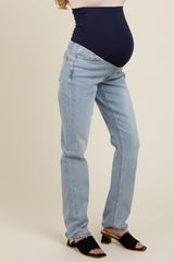 woman wearing light blue maternity jeans with a dark blue panel, showcasing a visible baby bump