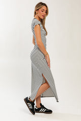 woman wearing a black and white striped maxi dress with side slits and paired with black sneakers