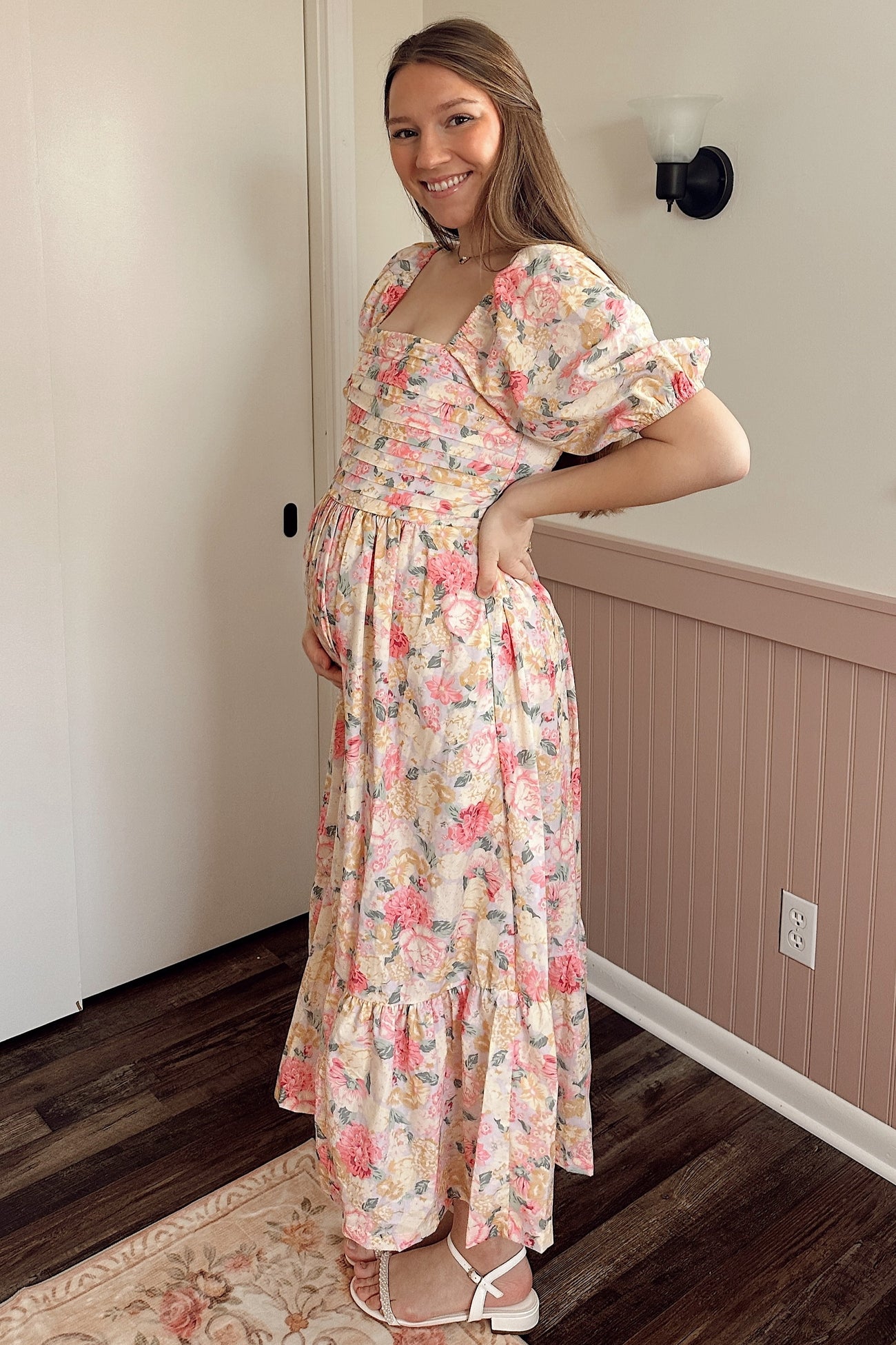 woman wearing a floral print maternity maxi dress with ruffled sleeves and a baby bump visible
