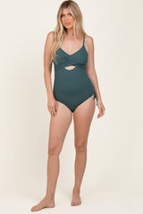 woman wearing a green ribbed one-piece swimsuit with a cutout and adjustable side ties