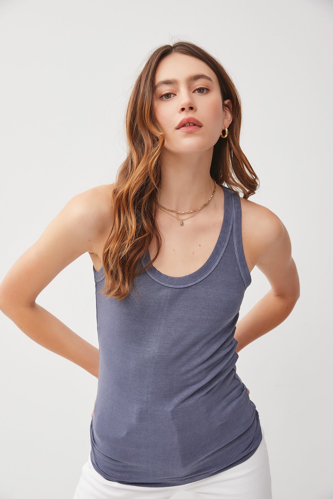 woman wearing a navy blue ribbed tank top with a scoop neckline and relaxed fit