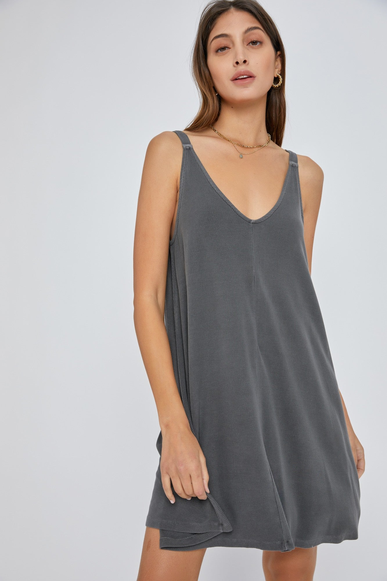 woman wearing a grey sleeveless casual dress with a deep v-neck and relaxed fit