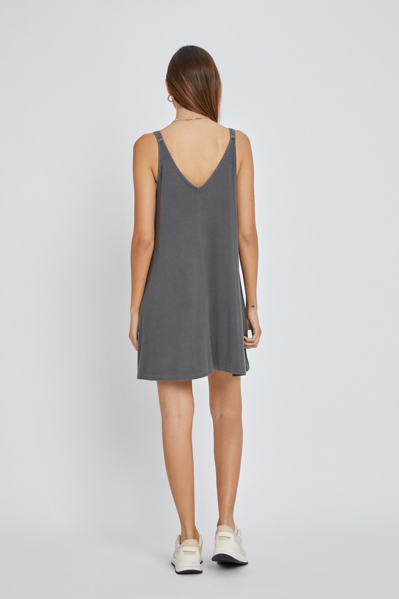 woman wearing a gray sleeveless dress with a v-back design and a relaxed fit