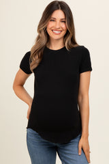 woman wearing a black short sleeve maternity top with a rounded hem and a visible baby bump