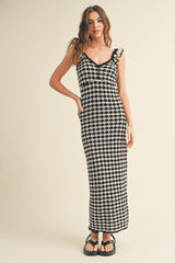 woman wearing a black and white checkered maxi dress with ruffle straps and a fitted silhouette