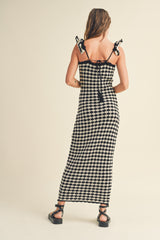woman wearing a black and white checkered maxi dress with shoulder ties and a fitted bodice from the back