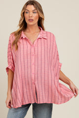 woman wearing a pink striped maternity button-up shirt, styled with rolled sleeves and a relaxed fit, showcasing her baby bump