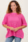 woman wearing a bright pink oversized knit sweater with short sleeves and a loose fit