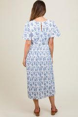 woman wearing a white floral print maternity dress with short sleeves and a pleated skirt, showing the back view