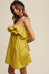 woman wearing a yellow off-the-shoulder dress with ruffle details and adjustable straps, styled with a black beret and choker